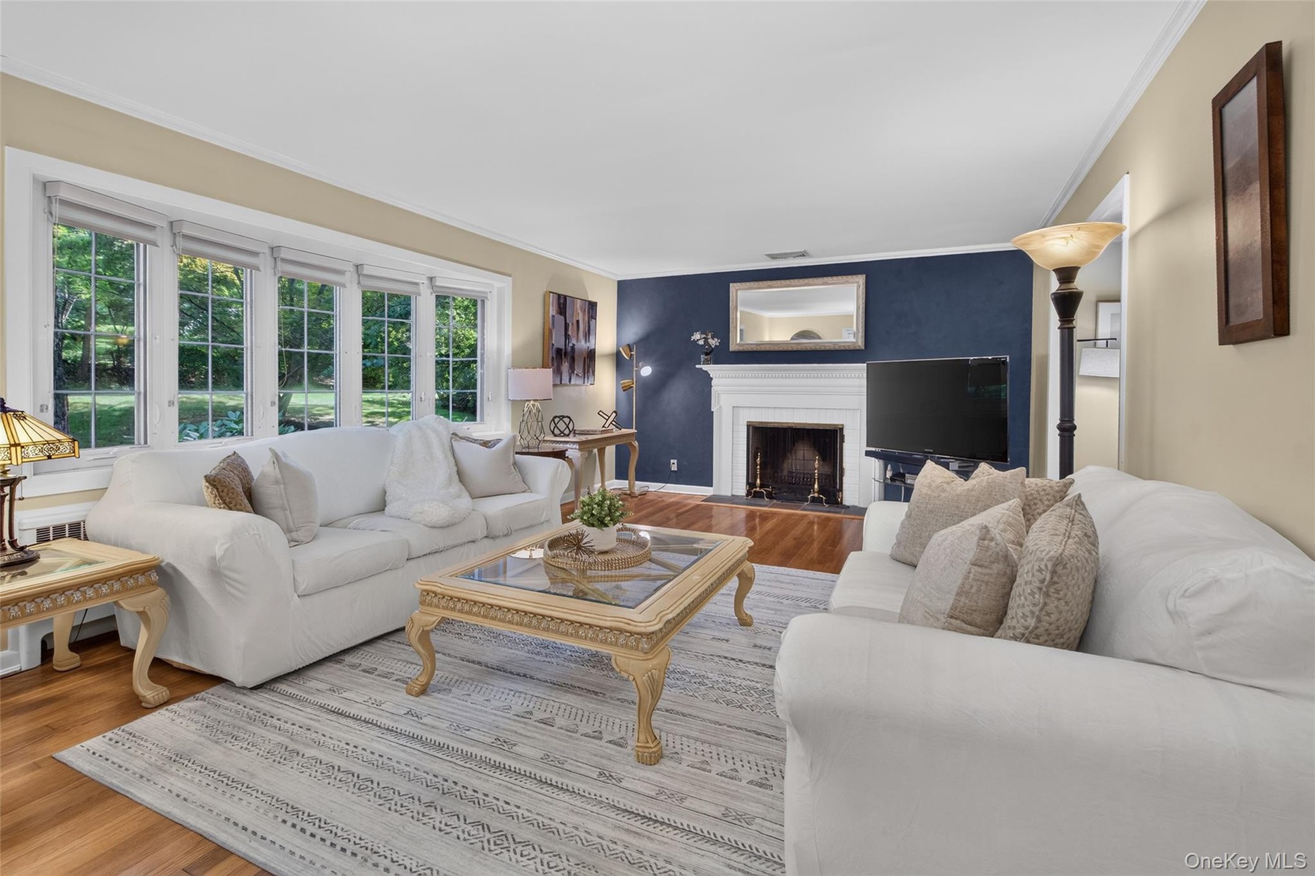 Large living room with bay window and wood buring fireplace