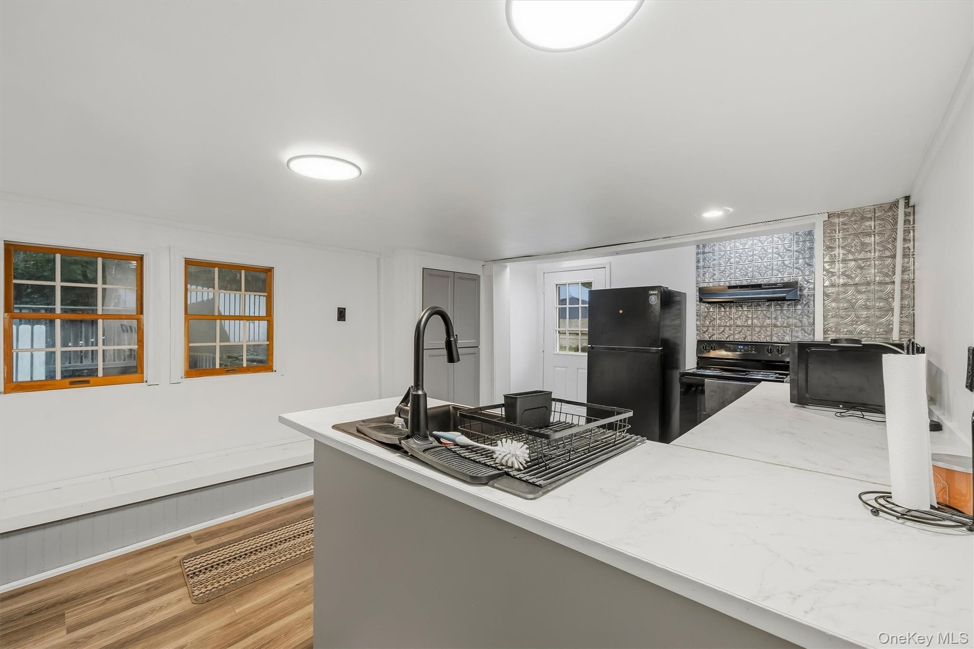 MAIN HOUSE - Another kitchen angle showing the center island, windows and open workspace.