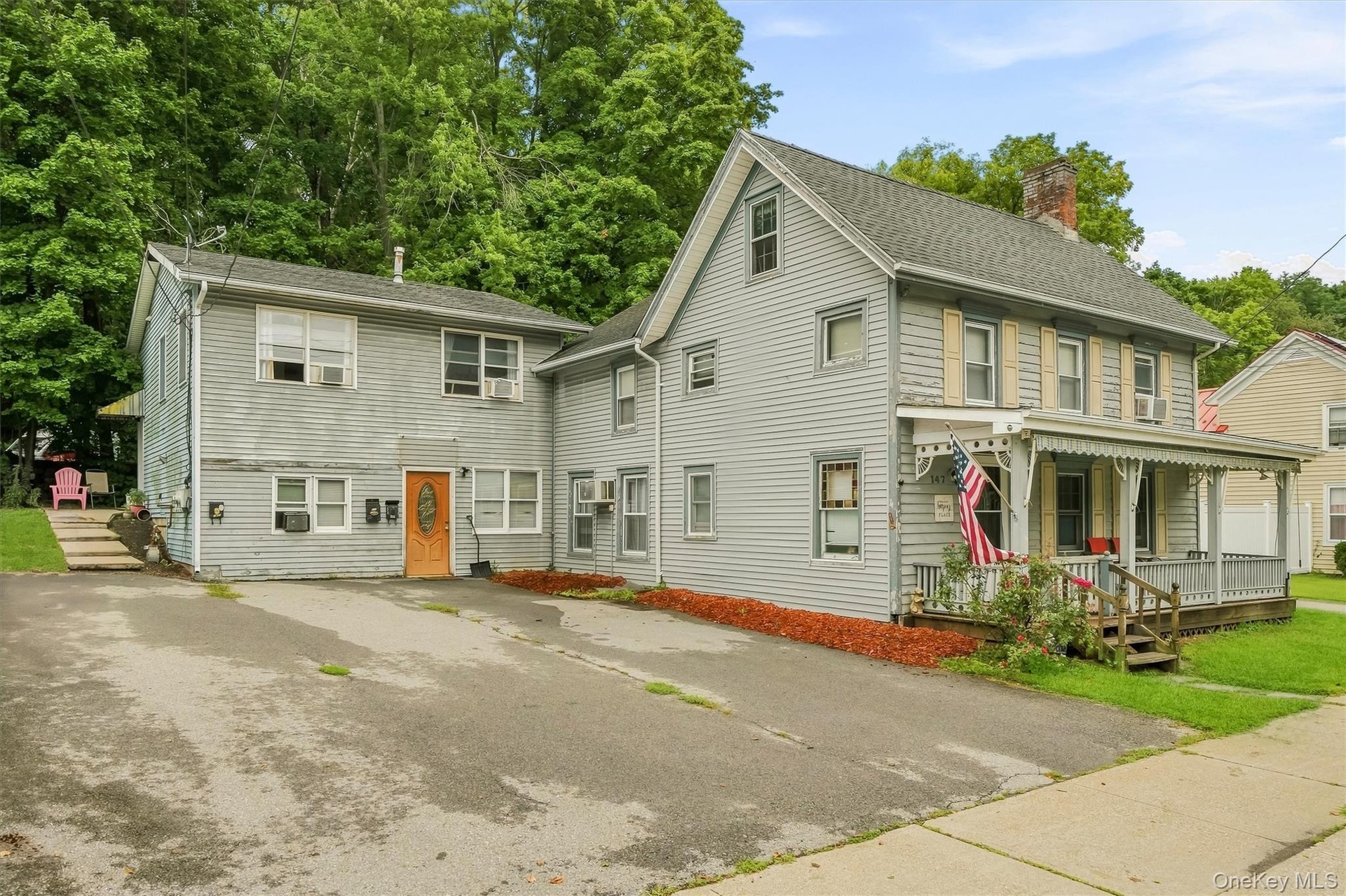 Side and rear exterior view showing the driveway and multiple entrances.
