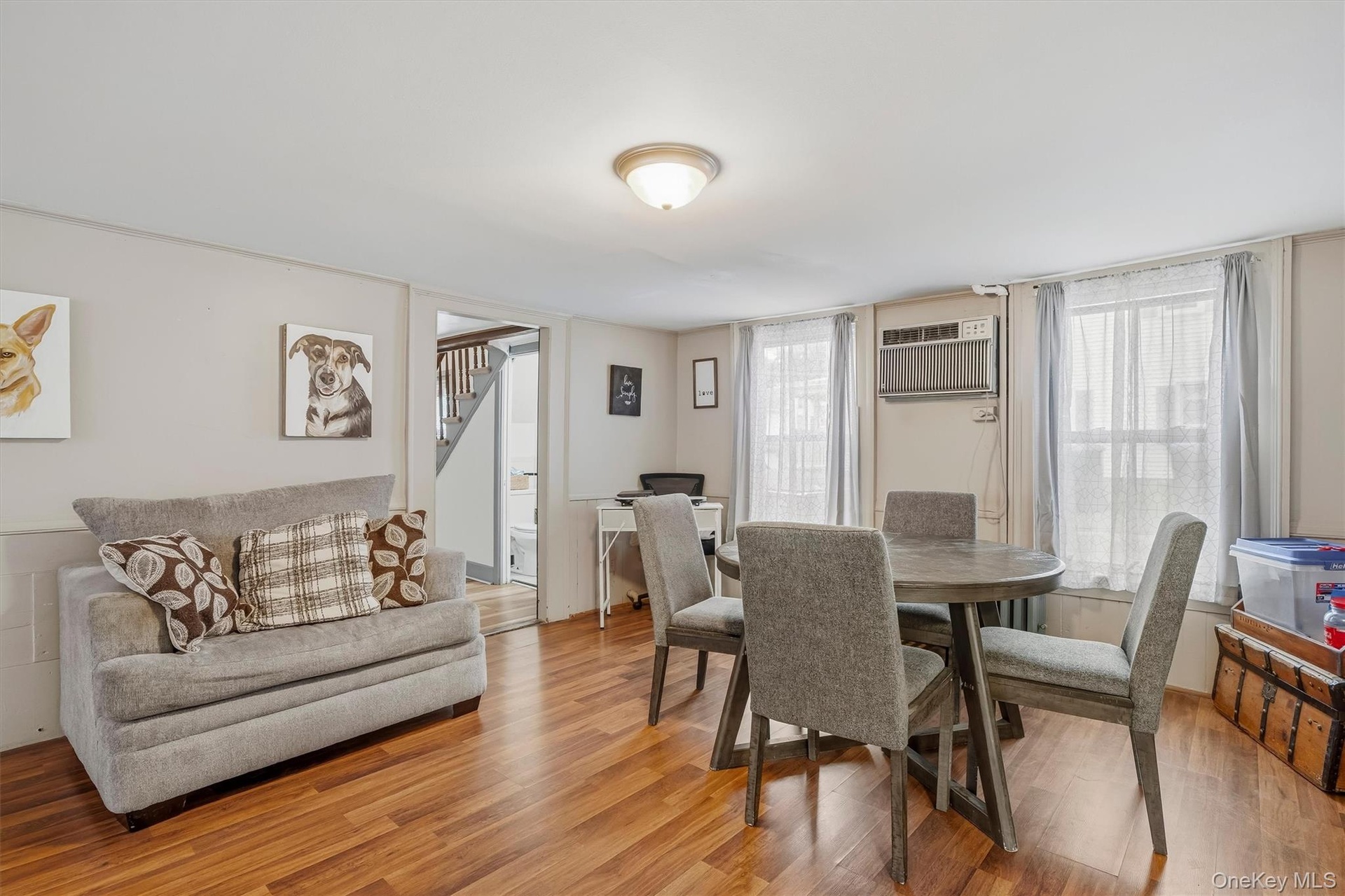 MAIN HOUSE - Dining area with wood-look flooring, multiple windows and access to the adjoining rooms.