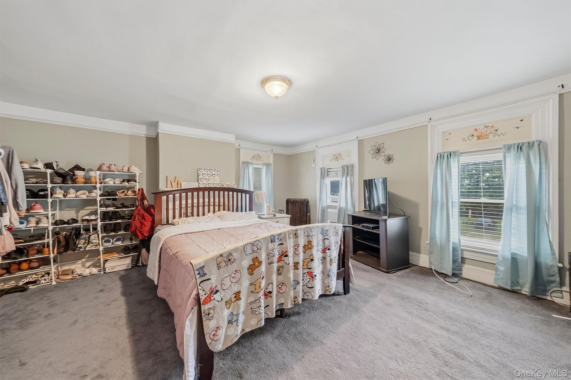 MAIN HOUSE - Spacious primary bedroom with room for multiple furniture arrangements.