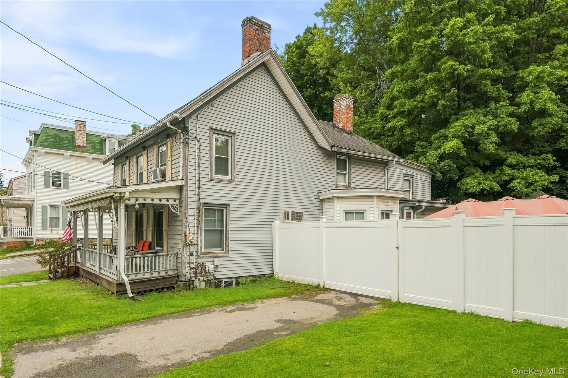 Side exterior view featuring the driveway, lawn and privacy fencing.