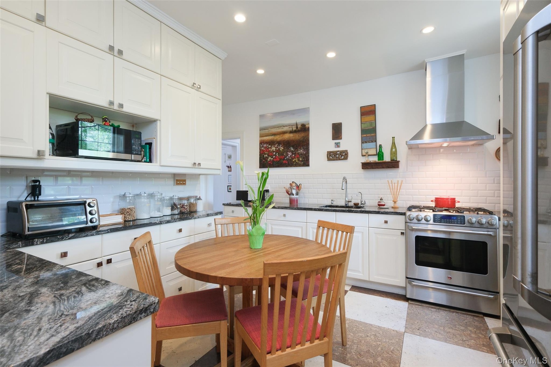 Apt. 4-B - Kitchen with recessed LED lighting, integrated appliances, full-height cabinetry, granite counters and cork flooring.