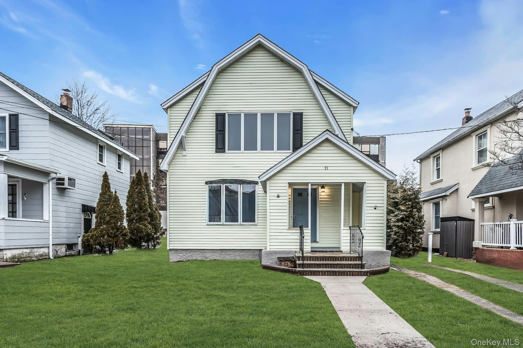 Two-story residence featuring light-colored siding and a covered front porch