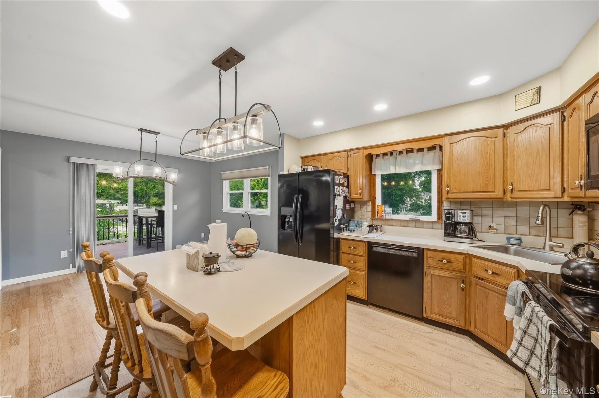 Kitchen with light-toned wood-finish flooring, a center island with counter seating, and light wood cabinetry