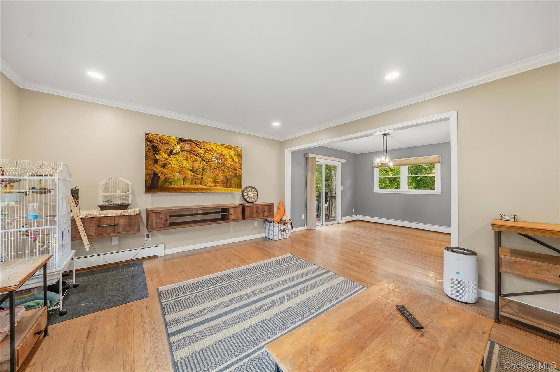 Hardwood flooring, recessed lighting, crown molding, and a built-in entertainment unit with wood-finish shelving