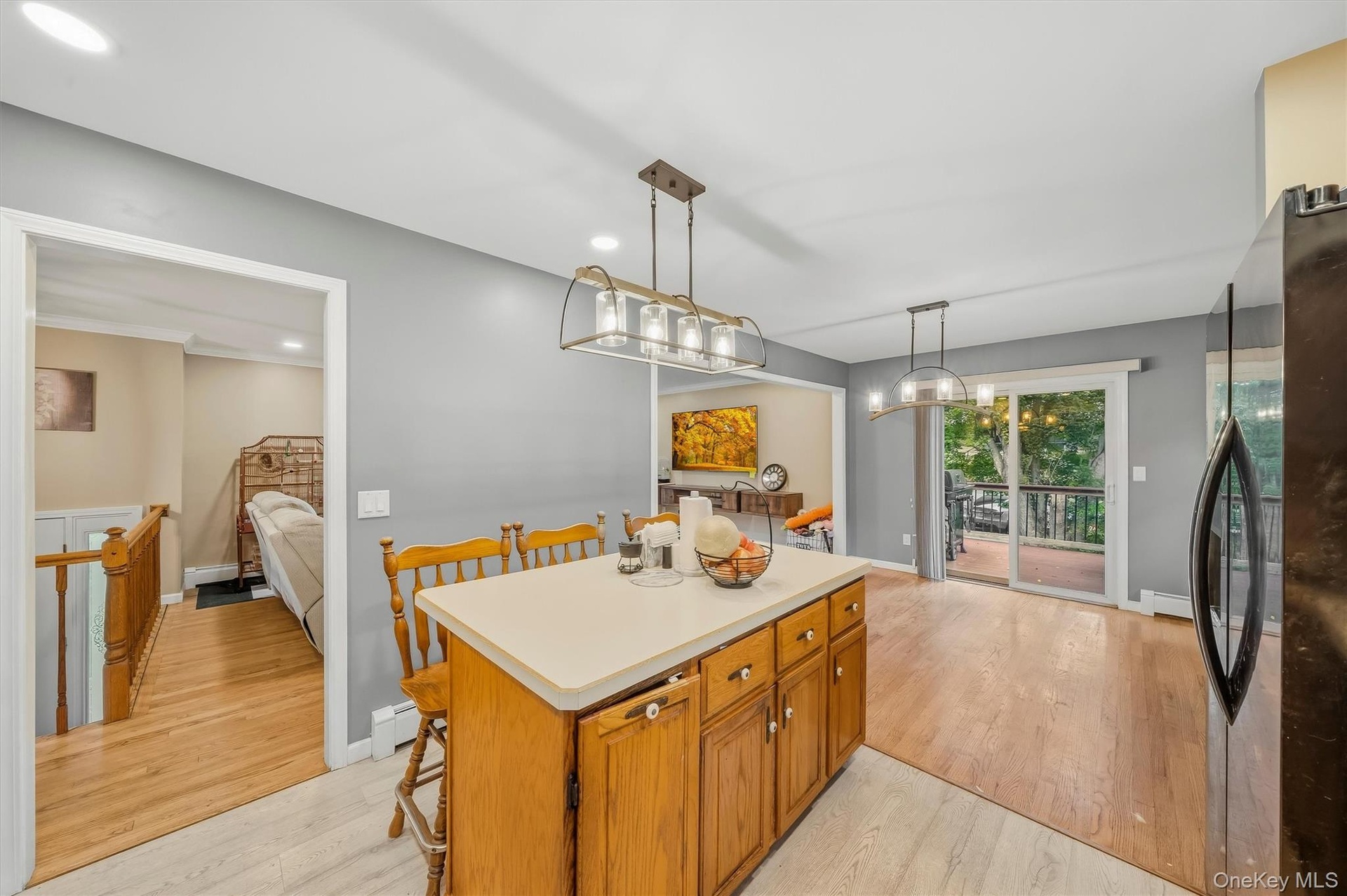 Kitchen island with wood-finish cabinetry and light-toned countertop, complemented by modern overhead lighting