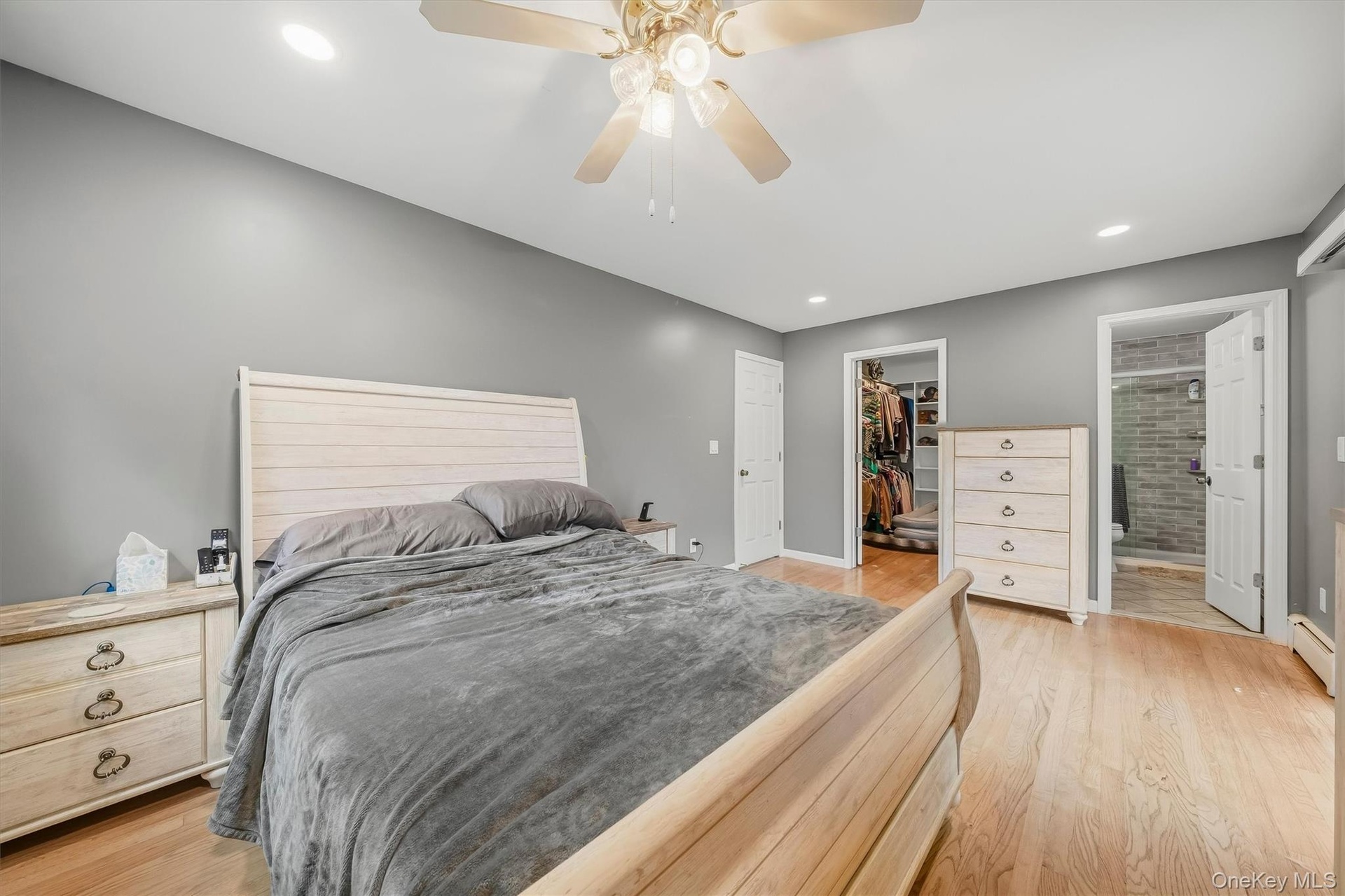 Hardwood flooring, recessed lighting, ceiling fan, walk-in closet, and an attached bathroom with a tiled shower