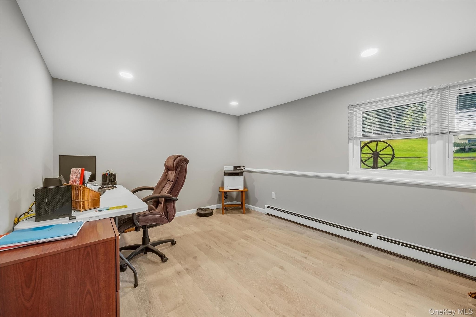 Recessed lighting, light wood-finish flooring, and a window with horizontal blinds