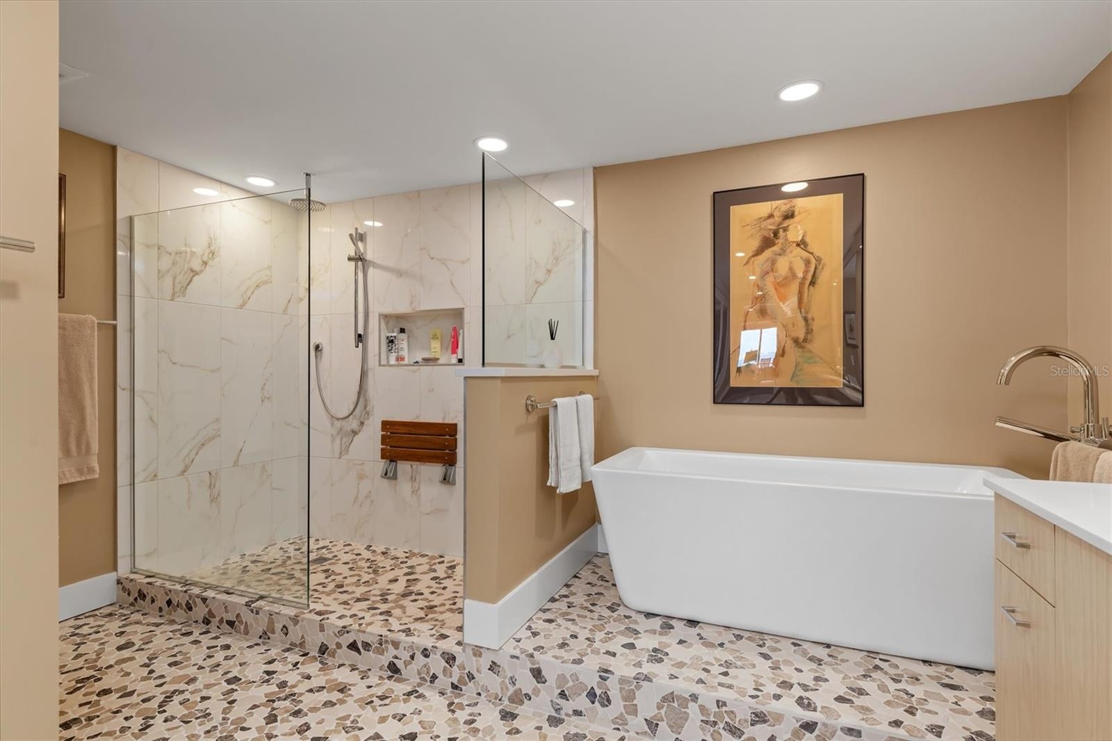 Teak fold down shower seat, frameless glass shower with multiple shower heads,  soaking tub
