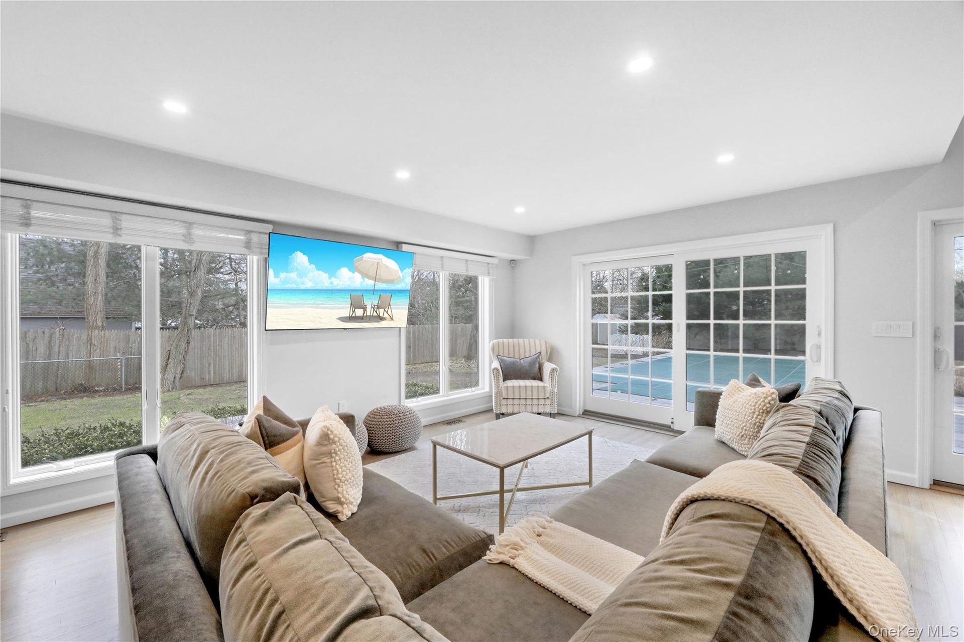 Living room with light wood finished floors and recessed lighting