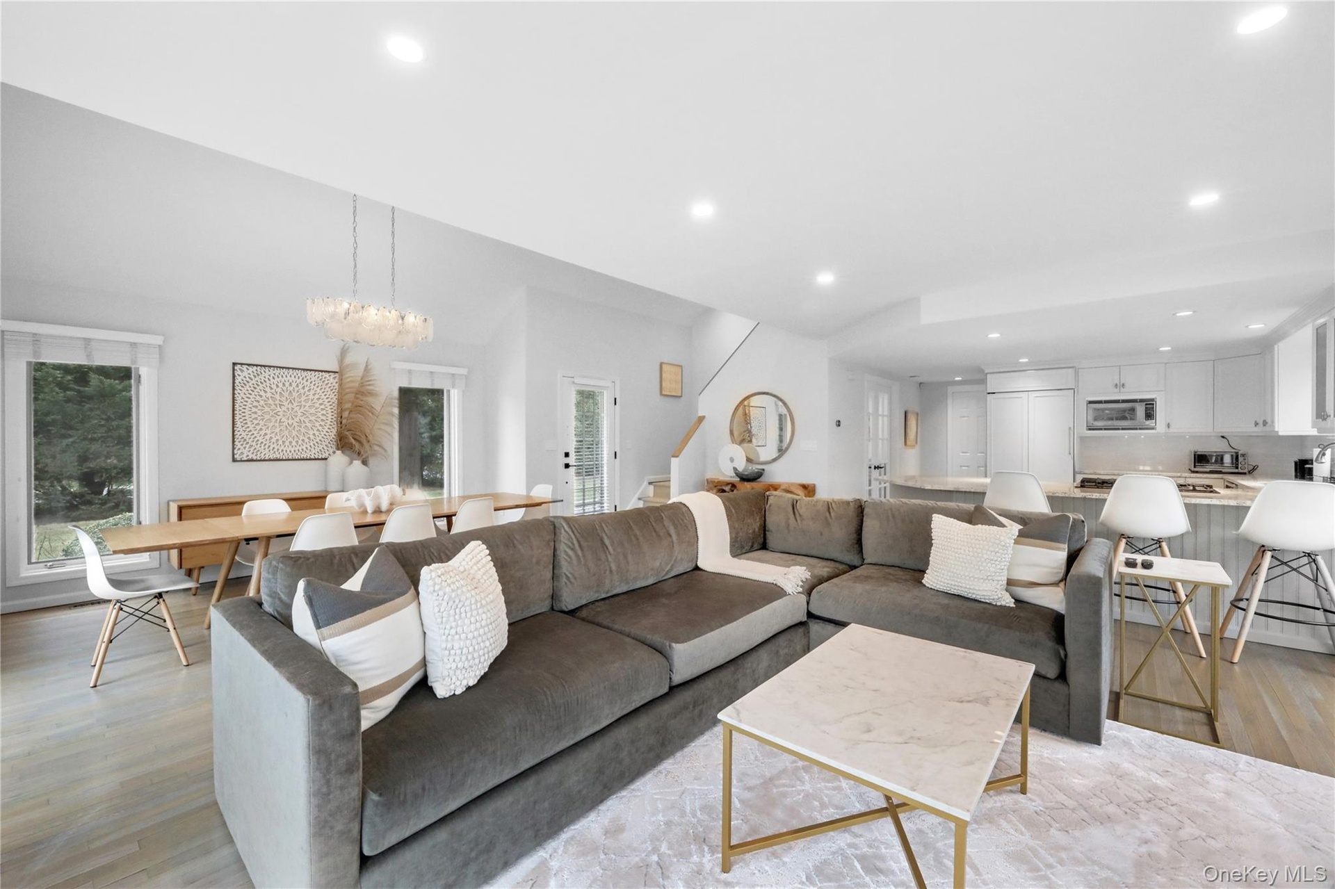 Living room with light wood-style floors, recessed lighting, a chandelier, and stairs