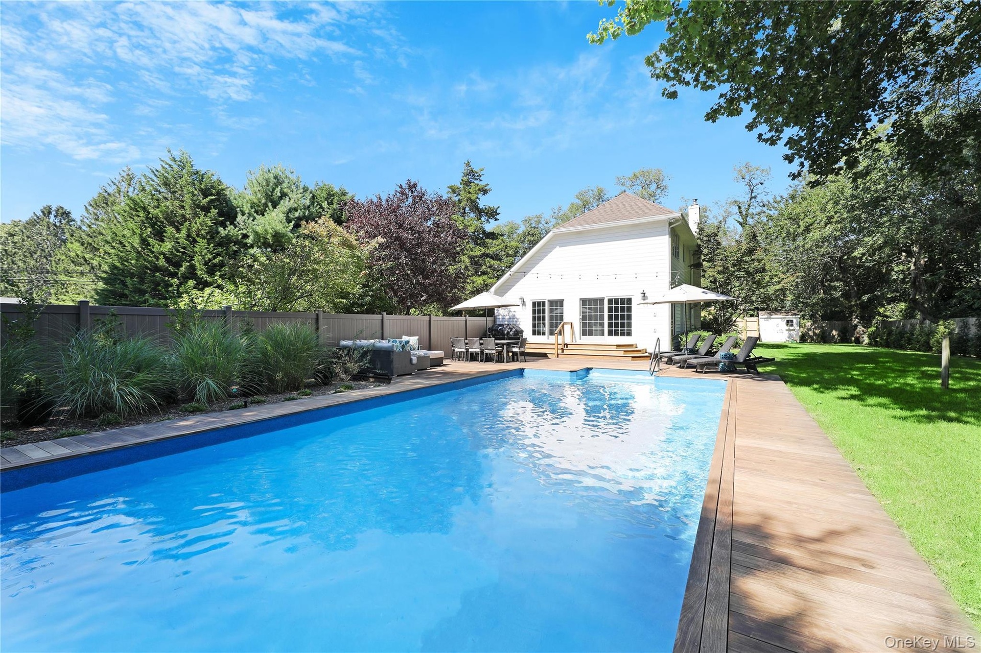 View of pool with an outbuilding, a patio, a fenced backyard, view of scattered trees, and an outdoor hangout area