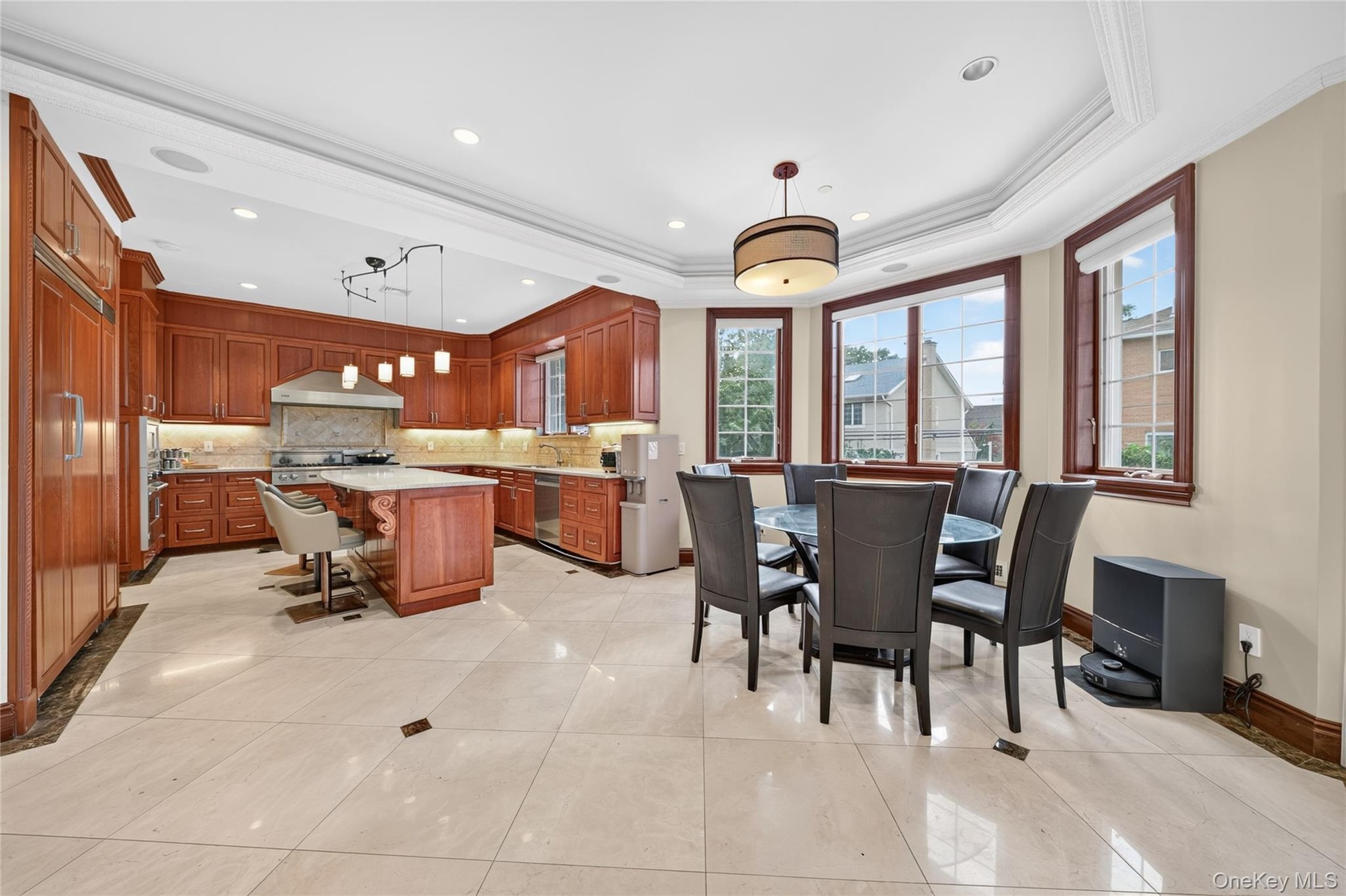 Gourmet kitchen with wood cabinetry, recessed lighting, and a center island with countertop seating