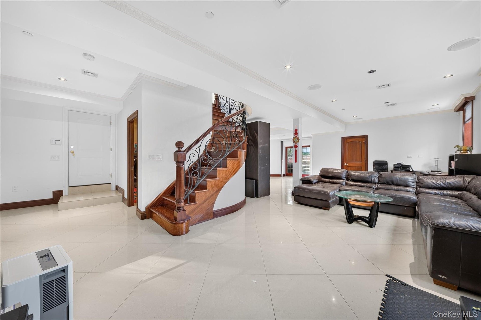 Spacious room featuring light-toned flooring, recessed lighting, and crown molding