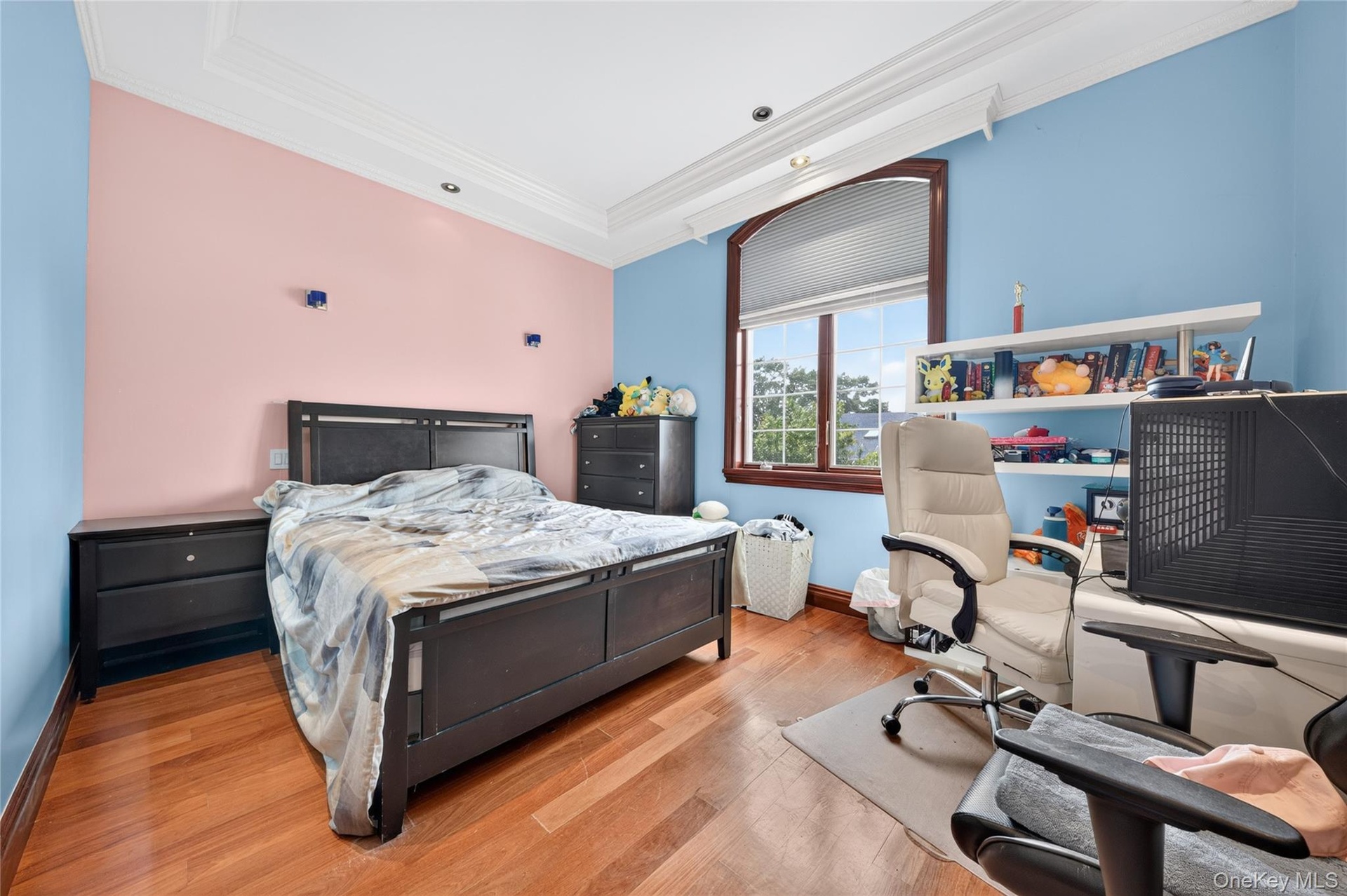 Hardwood flooring, recessed lighting, crown molding, and a large arched window with a wood frame