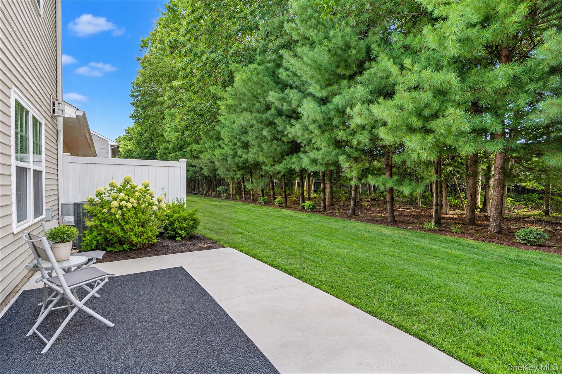 Private rear outdoor space bordered by mature landscaping