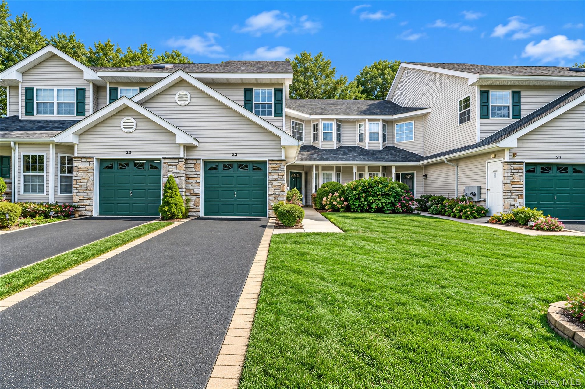 Front view with expansive driveway and attached garage