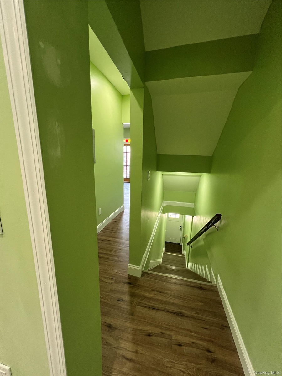 Hallway with wood-finish flooring and white baseboards