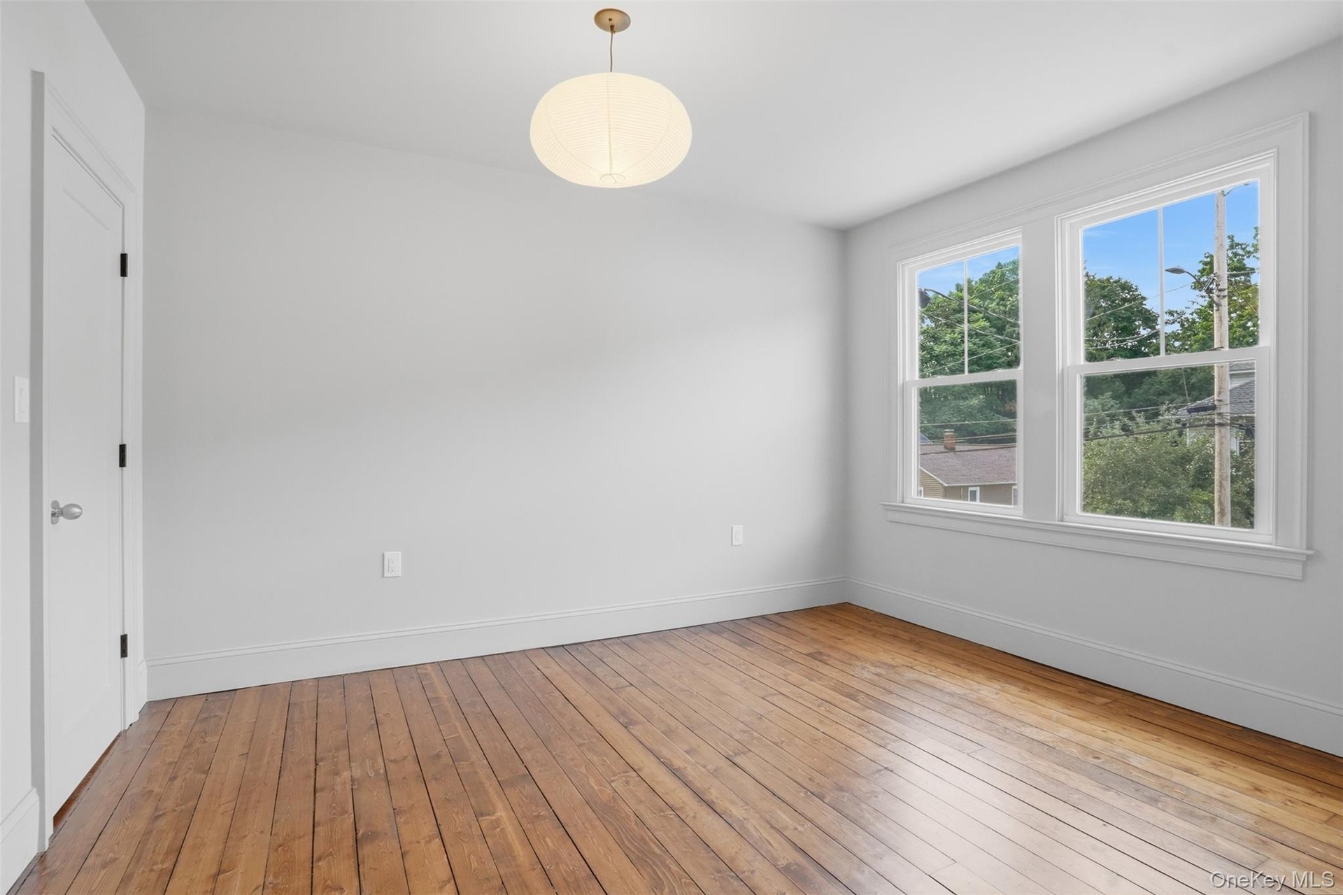Hardwood flooring, two windows, recessed lighting, white walls, and a white interior door