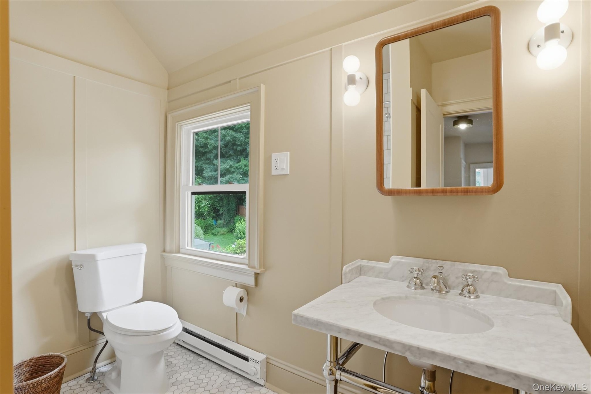 Pedestal vanity featuring a white marble countertop and integrated basin