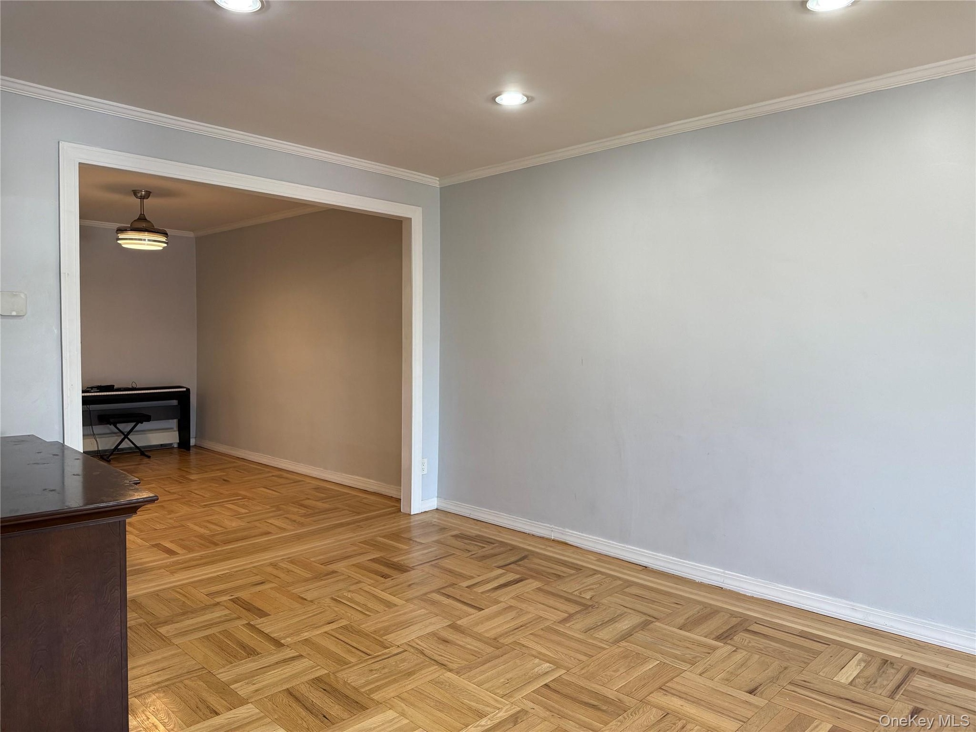 Recessed lighting illuminates the space, featuring crown molding and light-toned walls