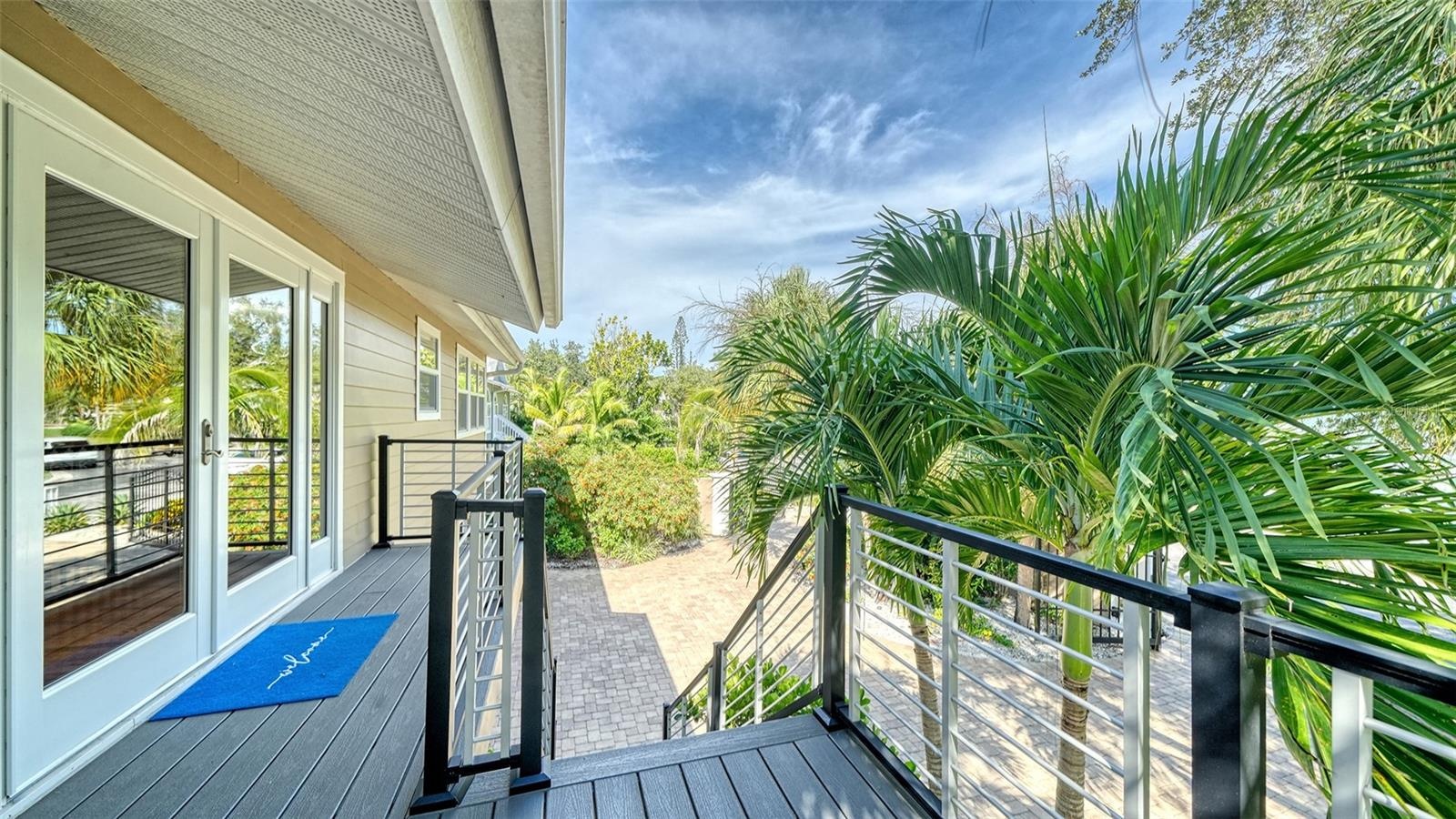 Elevated front entry surrounded by lush tropical foliage.
