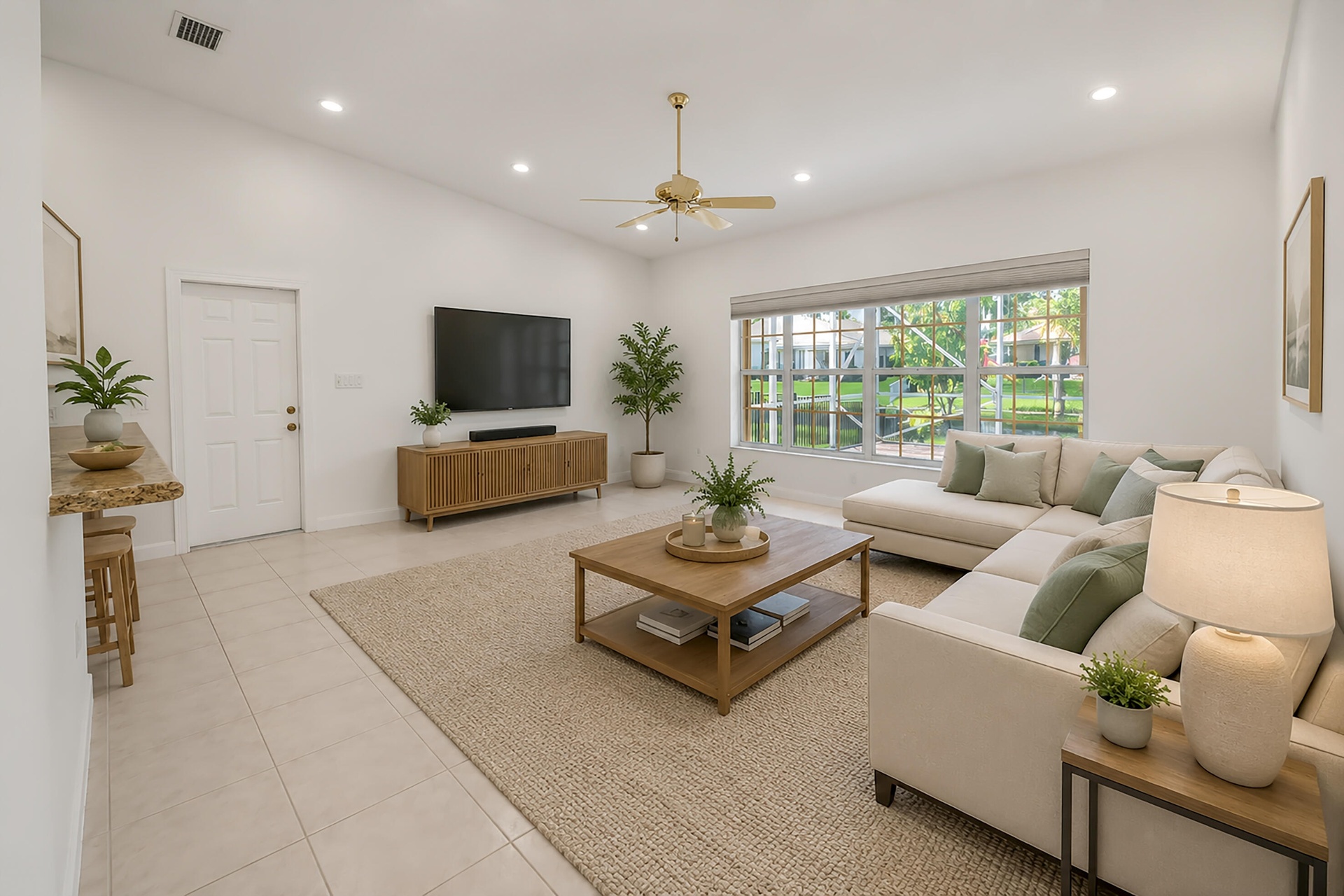 Vaulted ceilings enhance this living space featuring light-toned tile flooring, recessed lighting, and a prominent multi-pane window
