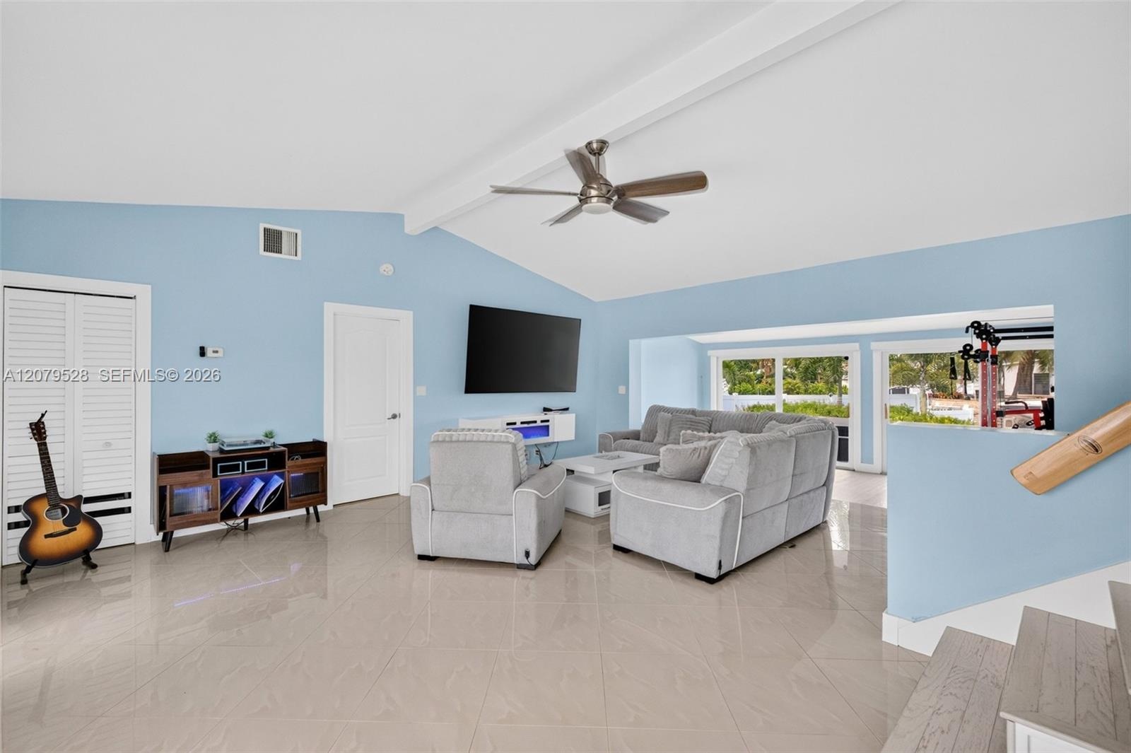 Living rm on main level. Primary bedroom to left. stairs up and down to the right. Volume beamed ceilings, impact windows, plantation shutters