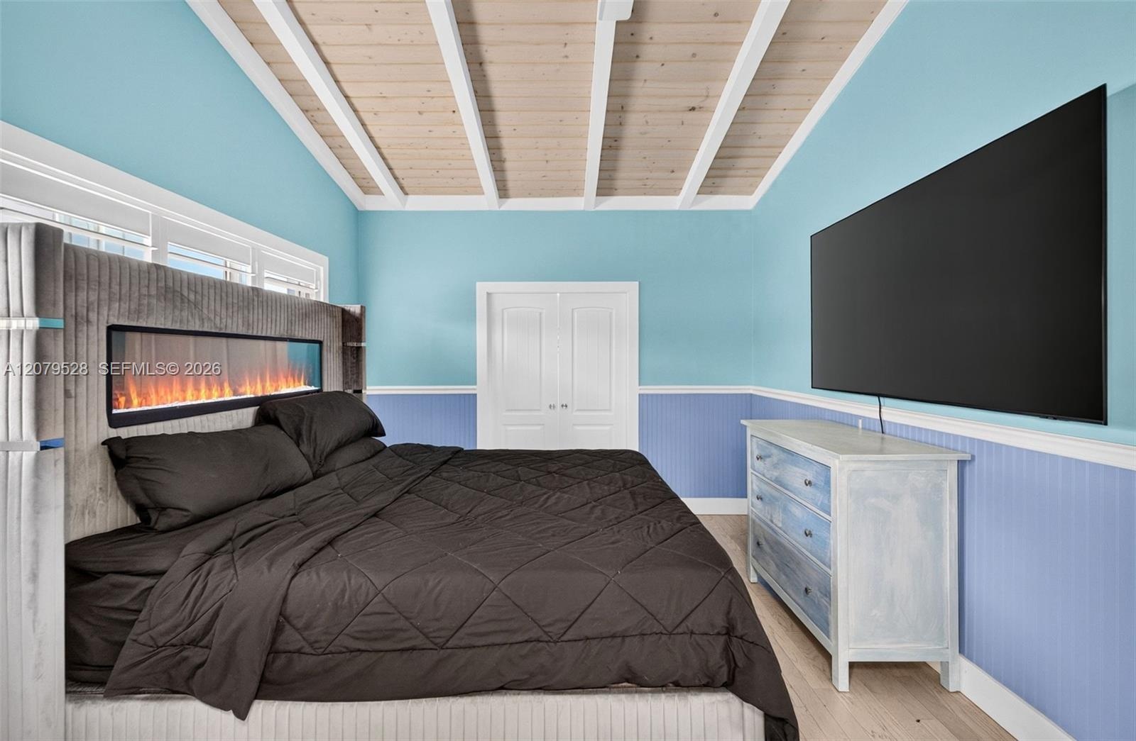 Oversized primary bedroom w/ beamed ceiling, Plantation Shutters and large walk in closet, en suite bathroom, on main level. Virtually Staged.