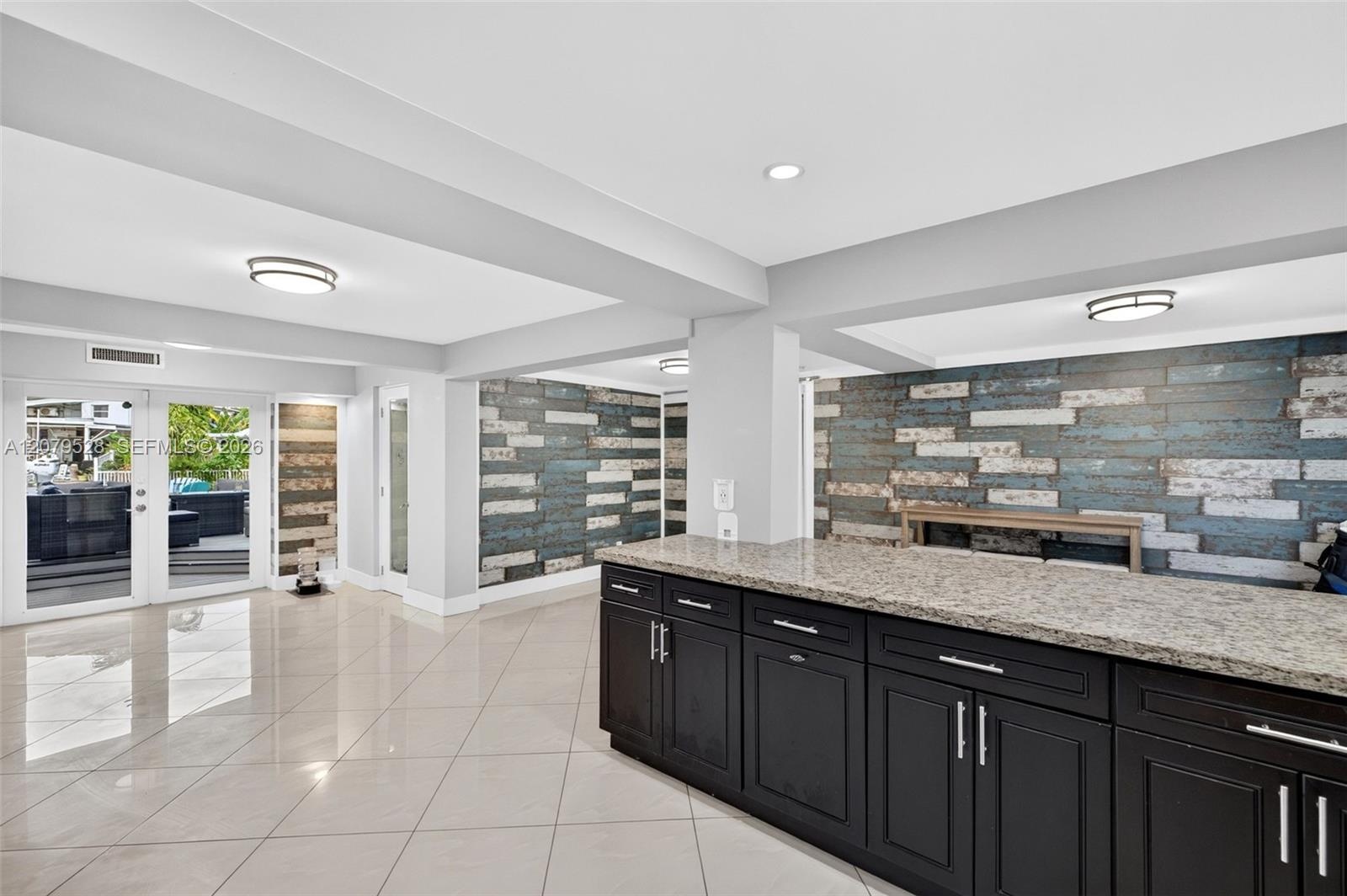 Large bright kitchen w/ windows everywhere, plantation shutters, wood cabinets, stainless appliances and granite counters