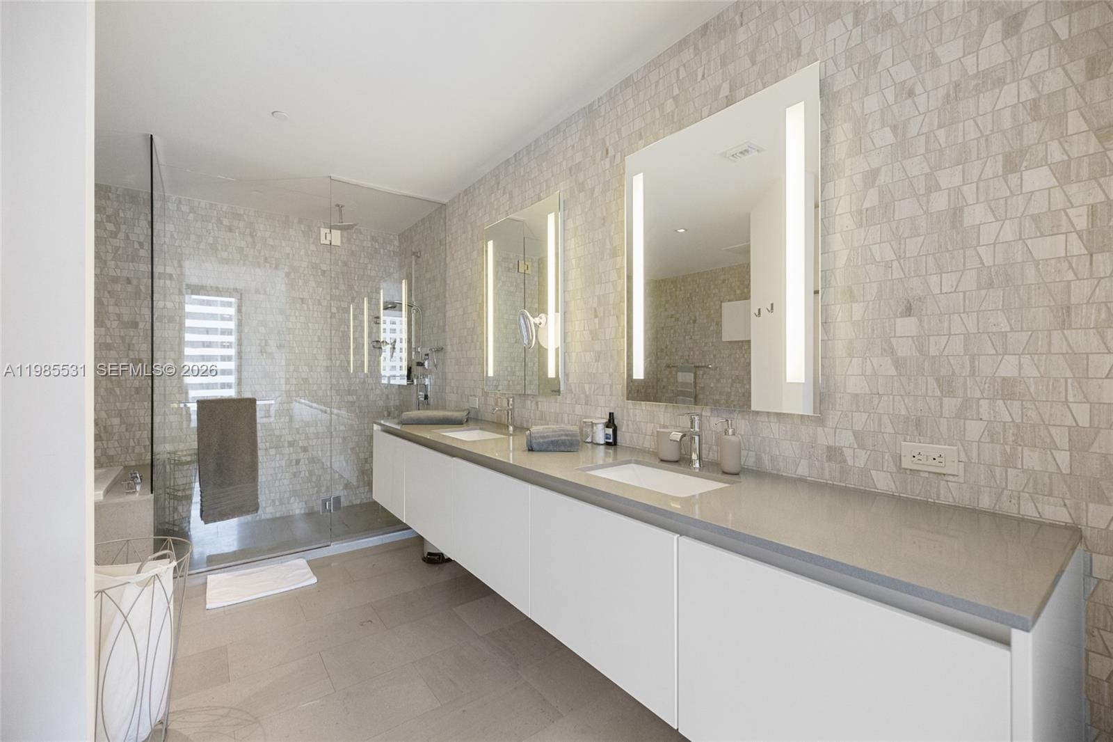 Floor-to-ceiling glass sliding door, balcony access, light-toned tile flooring, and neutral wall finishes