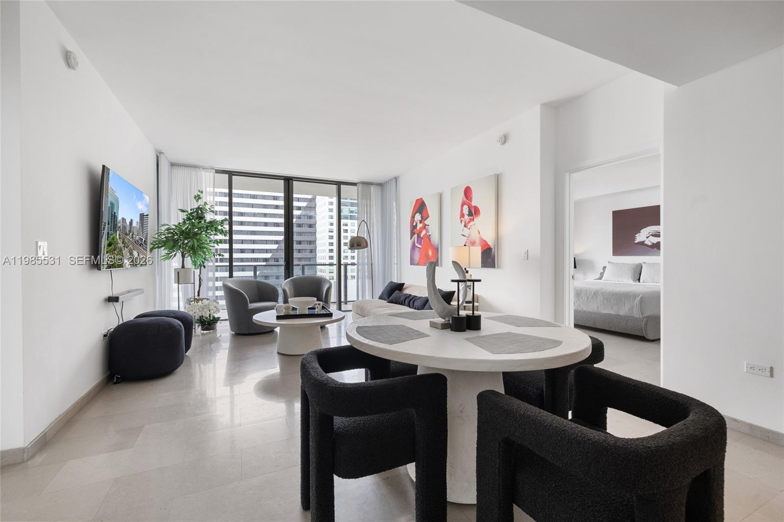 Open-concept interior featuring large-format tile flooring, recessed ceiling lighting, and a modern kitchen with flat-panel cabinetry and stainless st