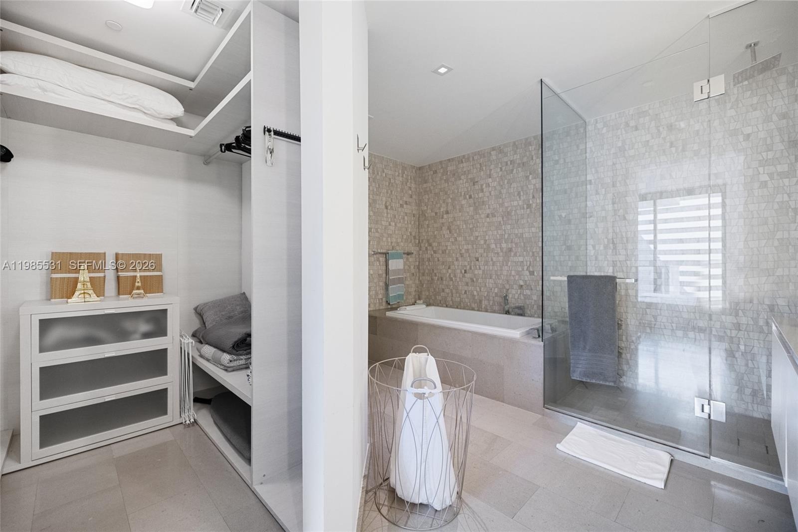 Modern wall-mounted vanity featuring a light-toned solid surface countertop, integrated sink, large-format frameless mirror, and polished chrome fauce
