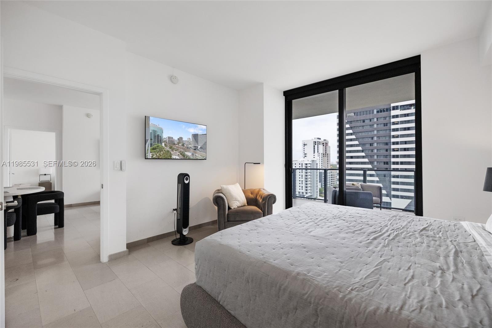 Covered private balcony featuring wood-finish flooring and a glass-paneled railing