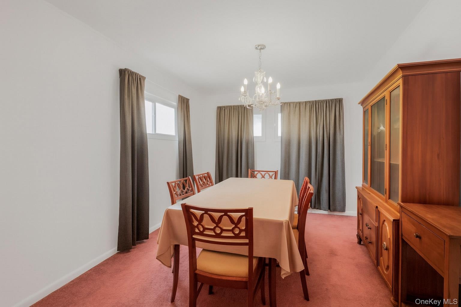 Dining area featuring light carpet and a chandelier