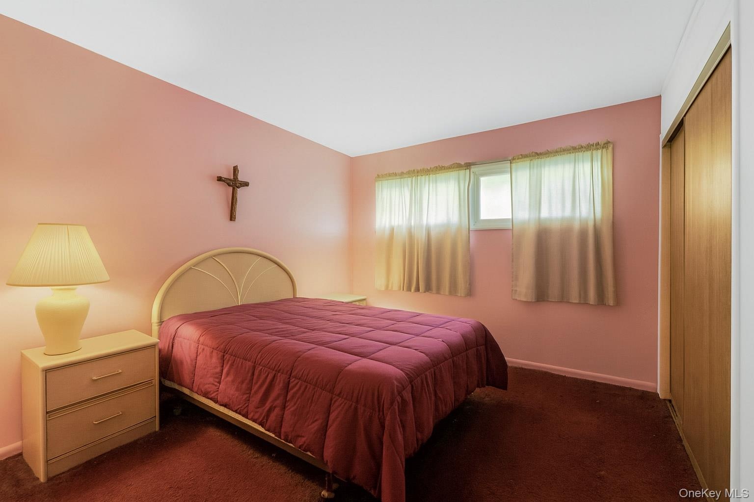 Carpeted bedroom with baseboards and a closet