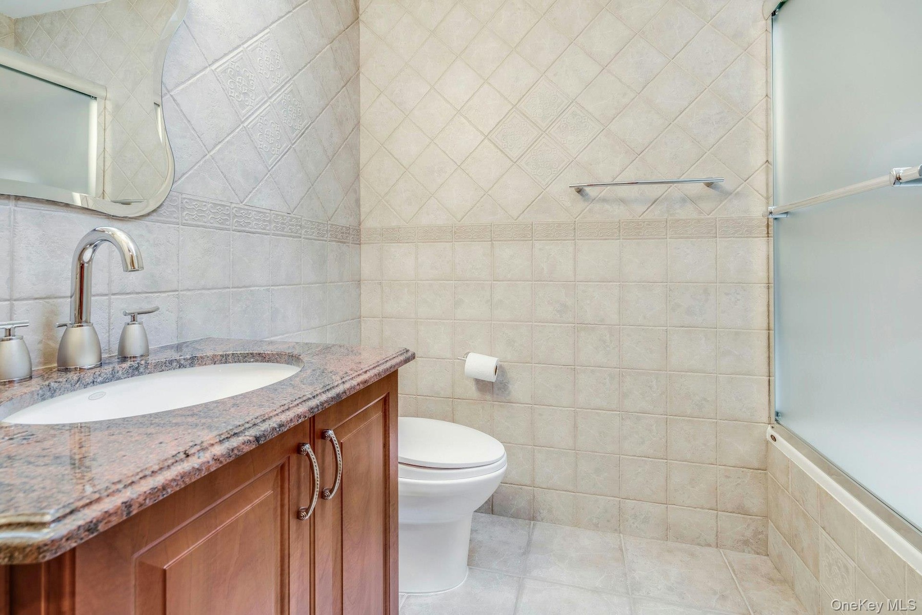 Bathroom with tub and frameless shower doors, granite vanity