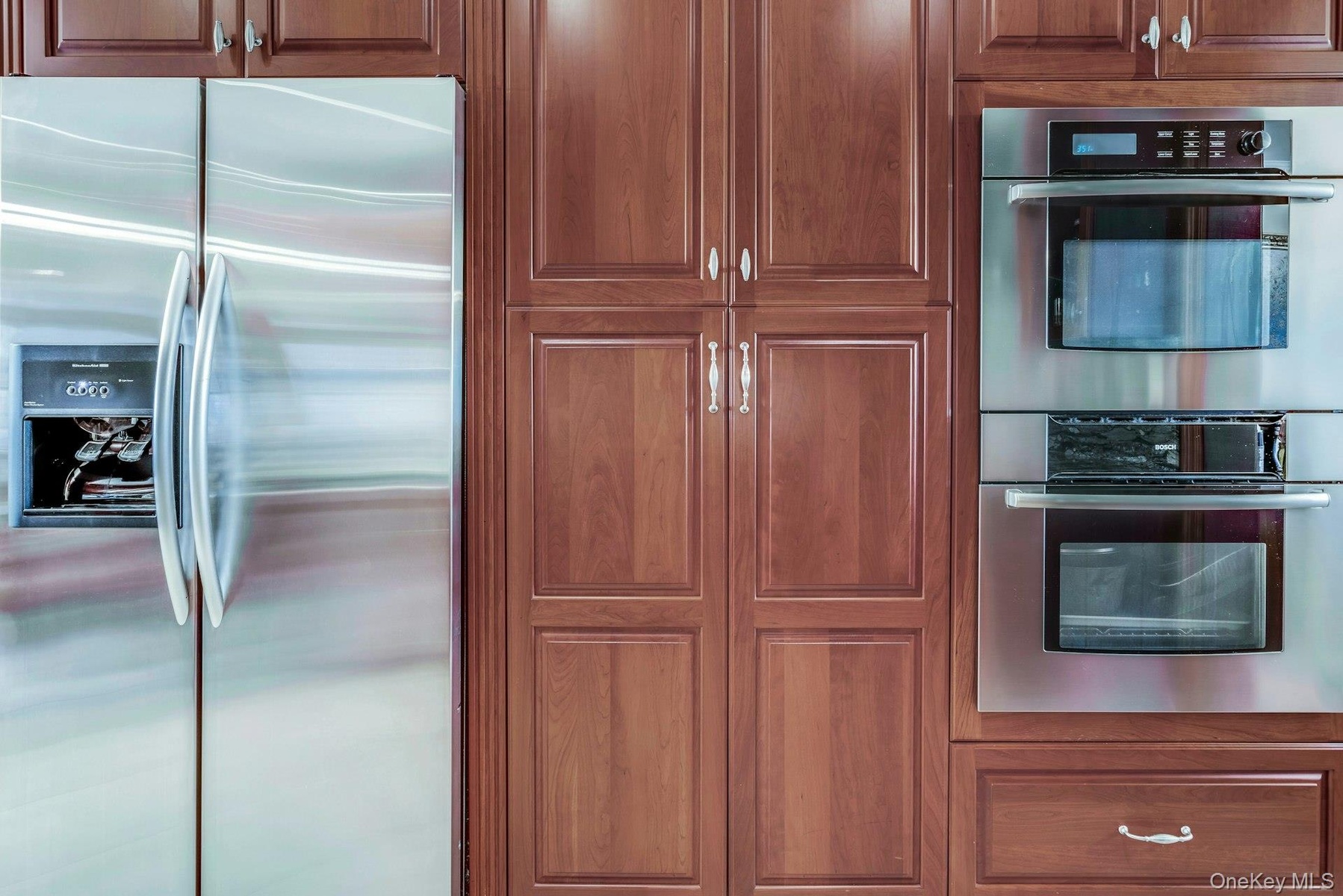 Stainless steel appliance including Bosch double oven and Kitchenaide French door refrigeraator with water and ice