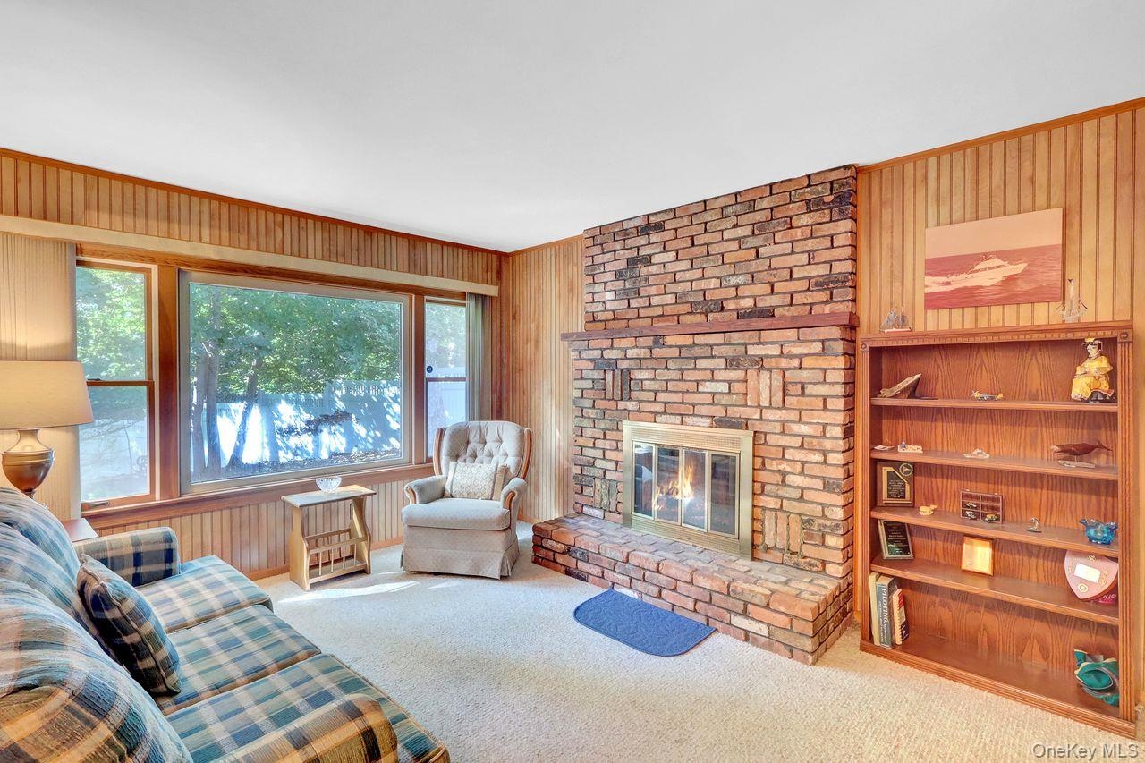 Brick fireplace with hearth,  and a large window over looking  the yard.