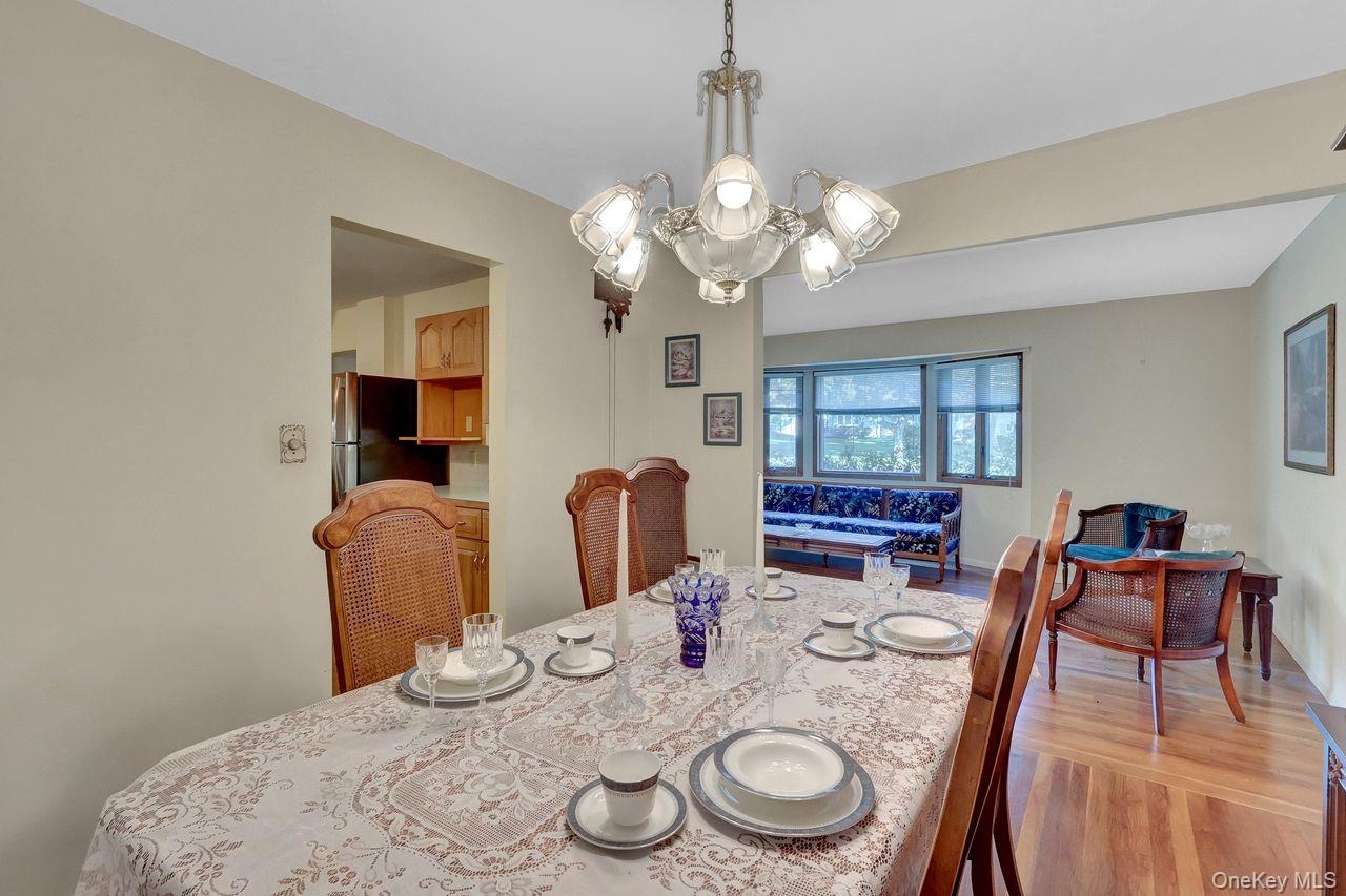 Wood-finish flooring, and a decorative chandelier illuminate the space