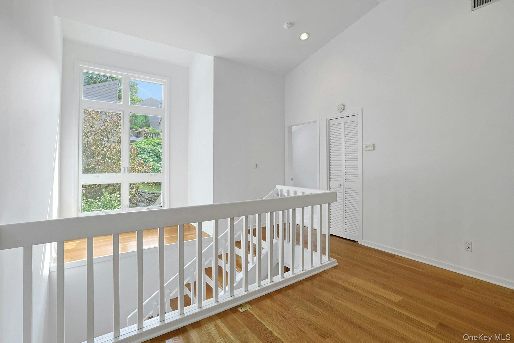 This view of the loft shows the door to the second bedroom as well as the view out to the neighborhood.