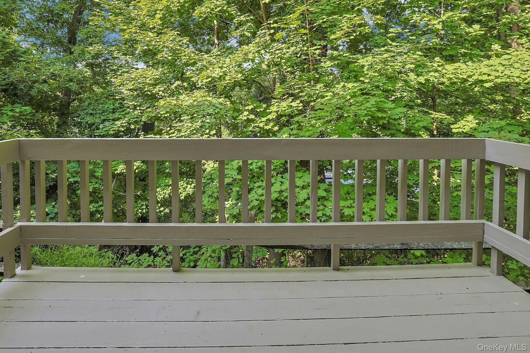The rear deck is ensconced by beautiful trees. This is a great spot to sit with a cup of coffee in the morning or, perhaps, something a little stronge