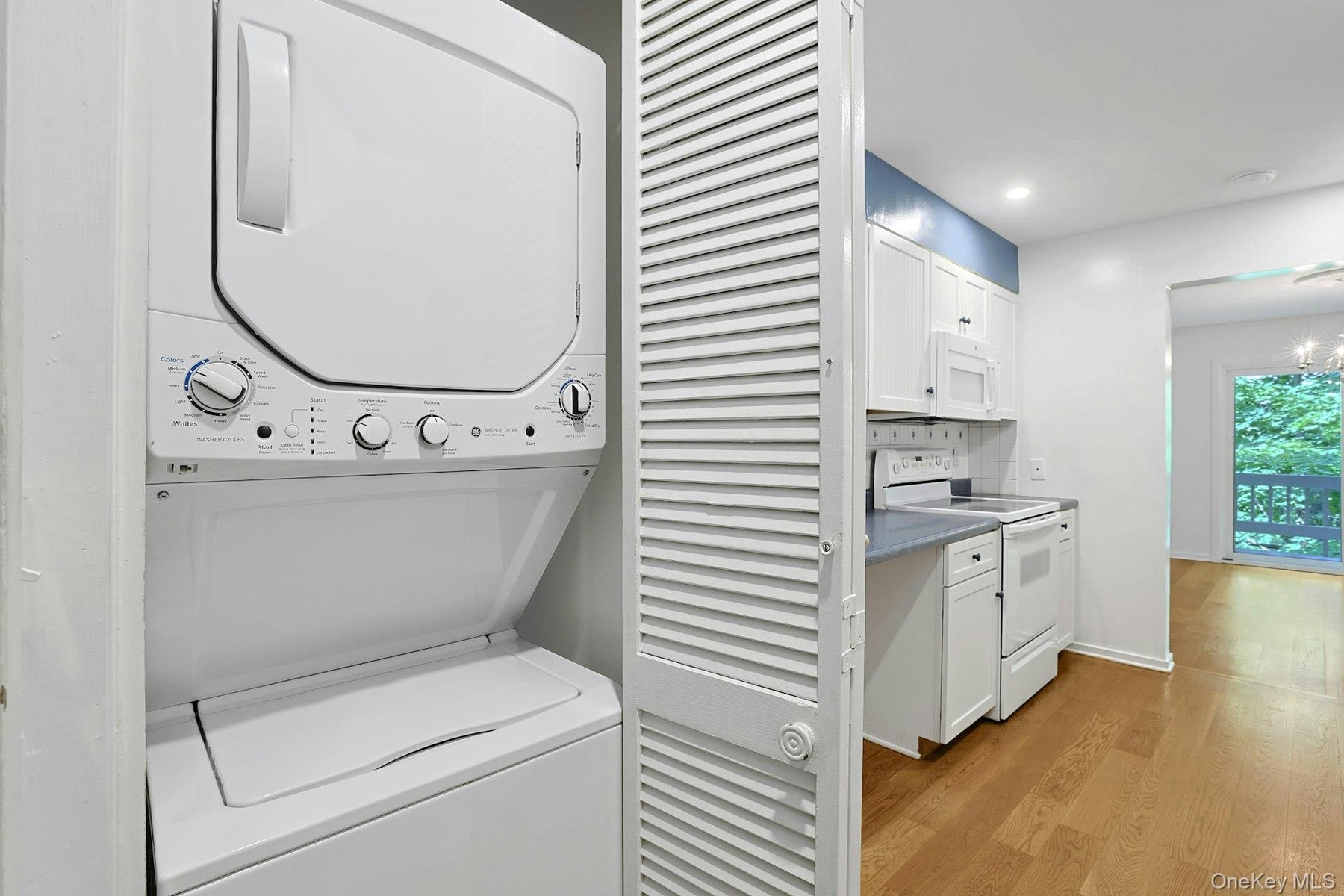 Conveniently located on the first floor, the laundry closet is hidden behind the slated doors. Just to the left is the garage door. Inside, the garage