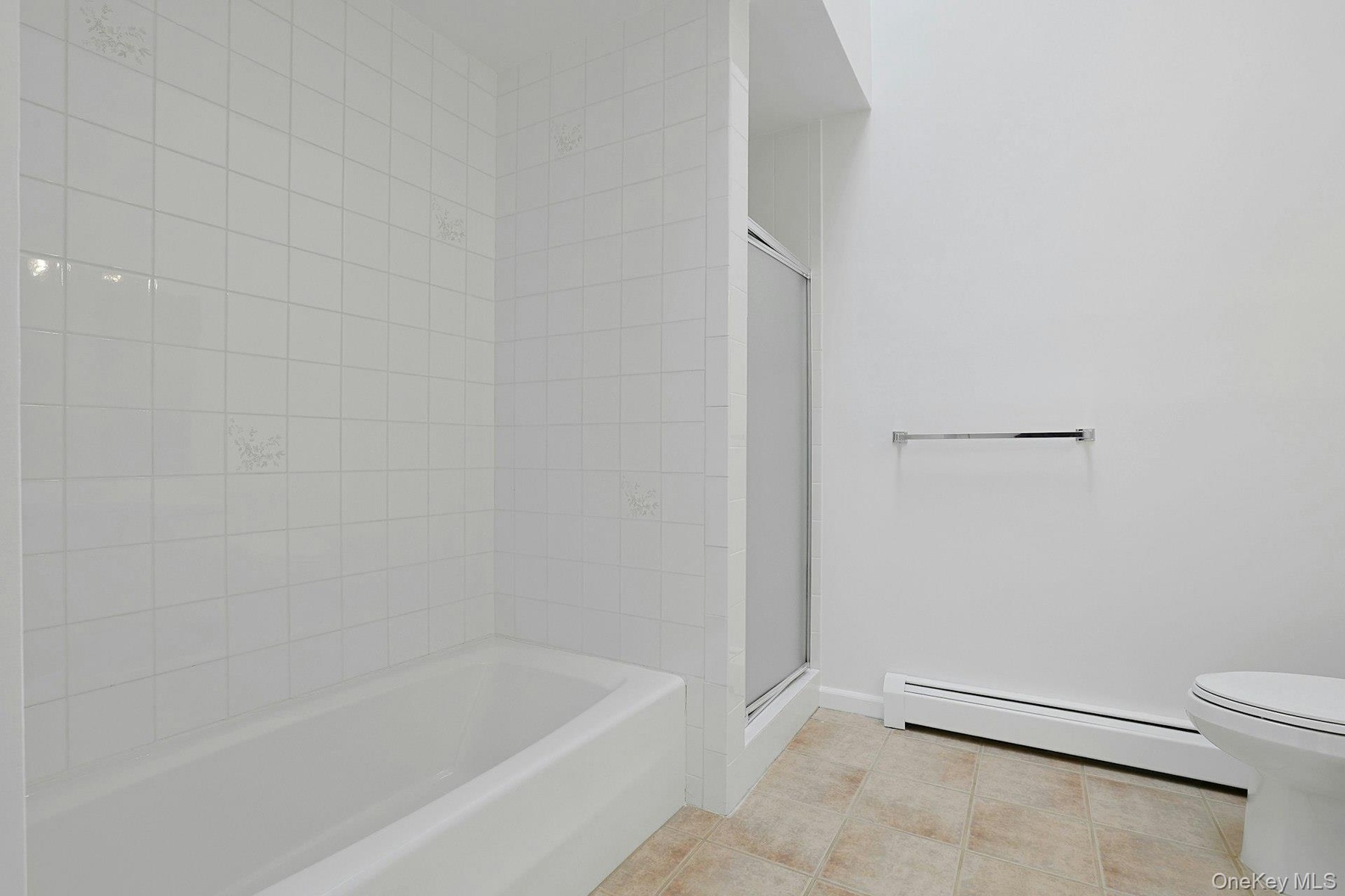 With both a tiled bathtub and a separate glass shower, the bathroom offers many options.