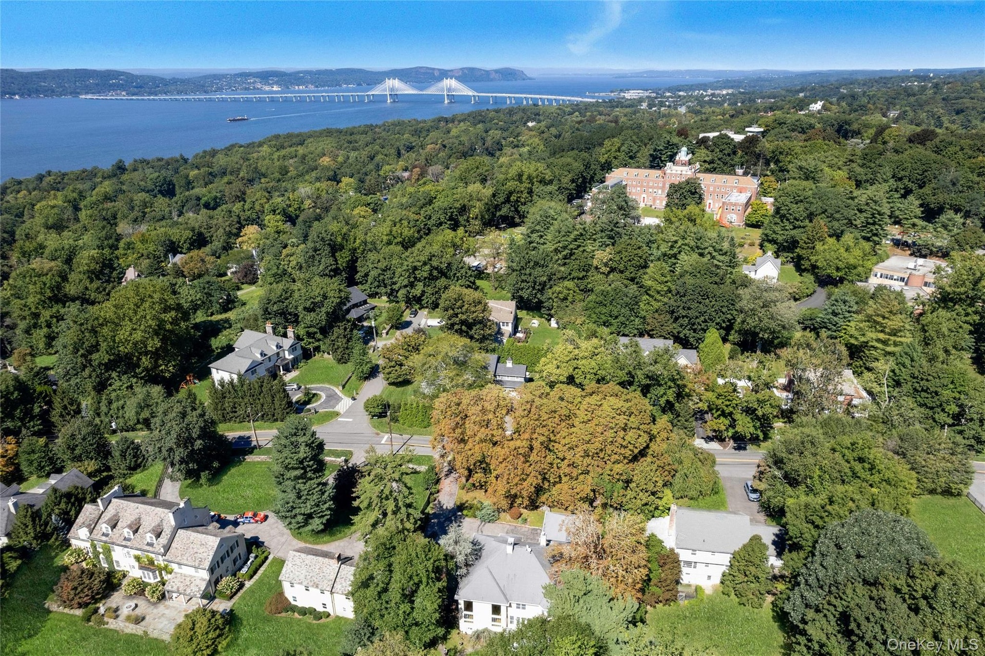 Lush, tree-lined neighborhood, view of the Hudson River and bridge.