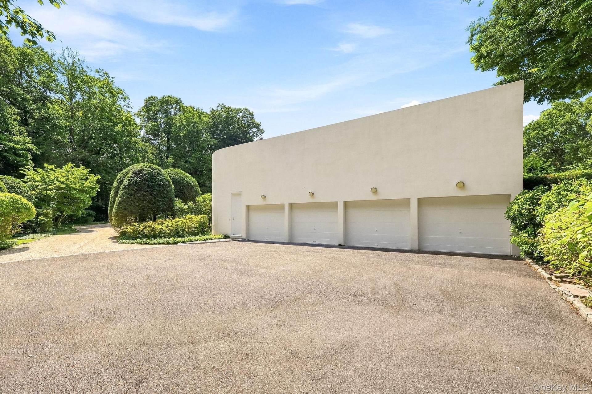 Expansive four-car garage with ample parking within the beautifully landscaped grounds.