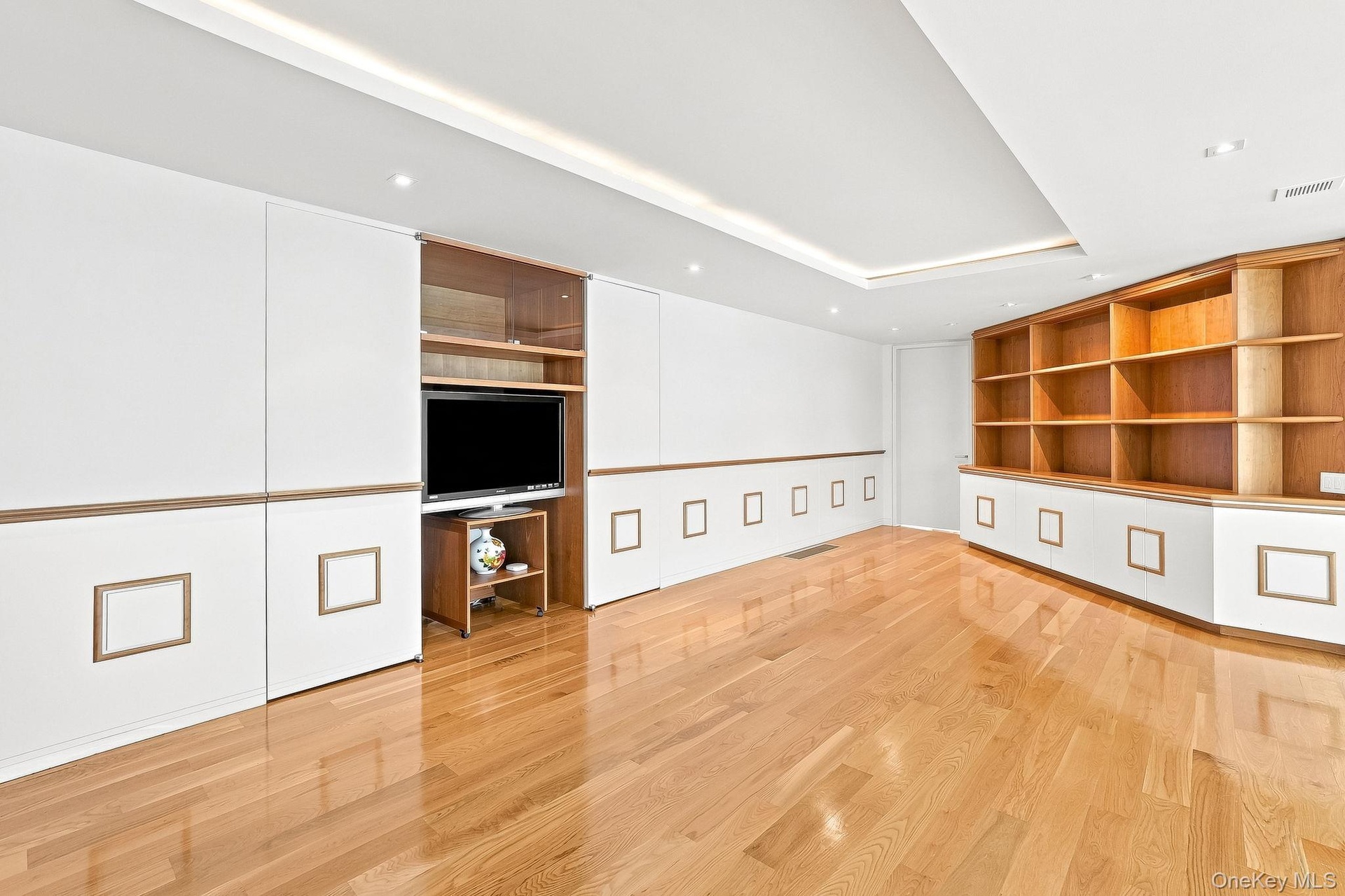 Landing area with built-in bookshelves and flat screen TV on second floor