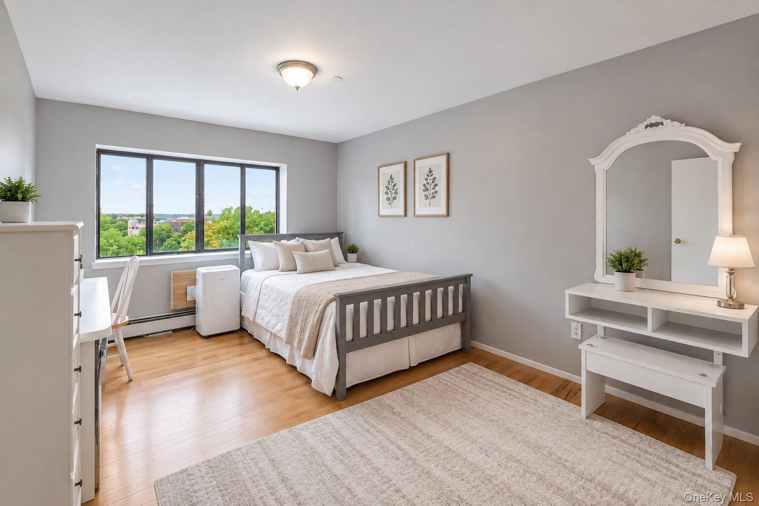 Hardwood-finish flooring and light gray walls create a neutral palette