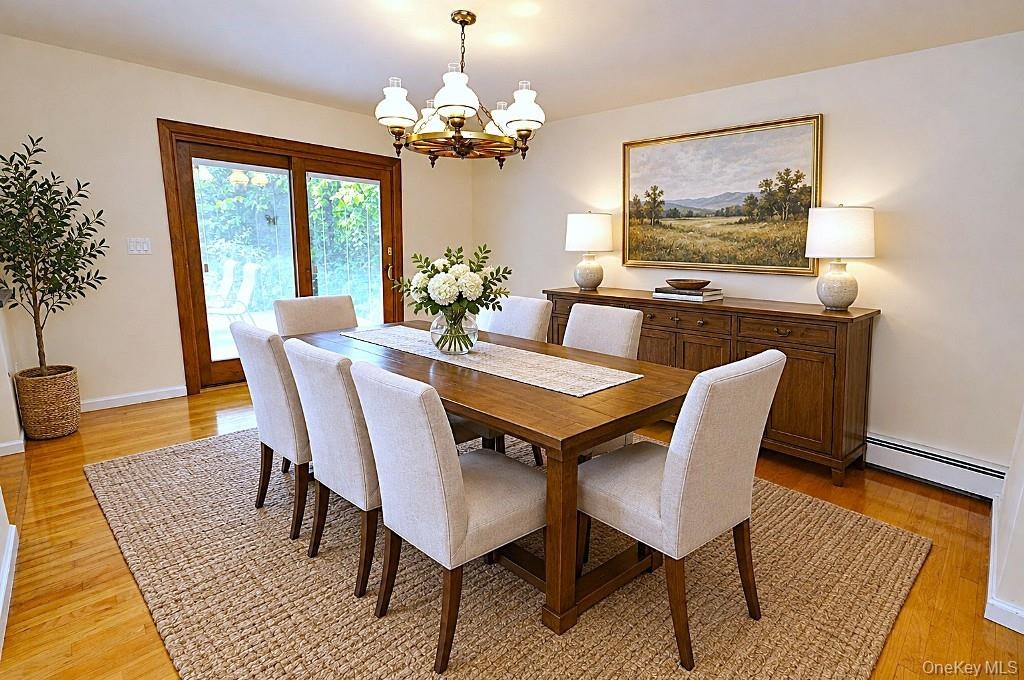 Photo Visually Staged.  Photo Visually Staged.  The Dining Room has hardwood floors, opens to both the Kitchen and Living room and has sliding glass d